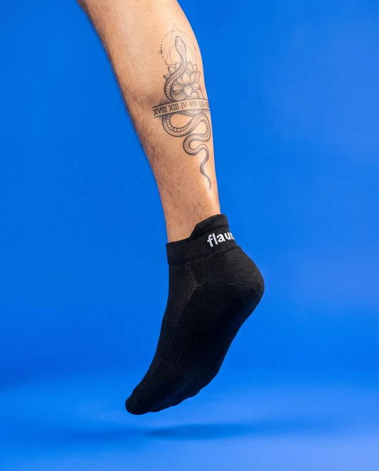 Flaunt Socks worn, foot hanging, blue background